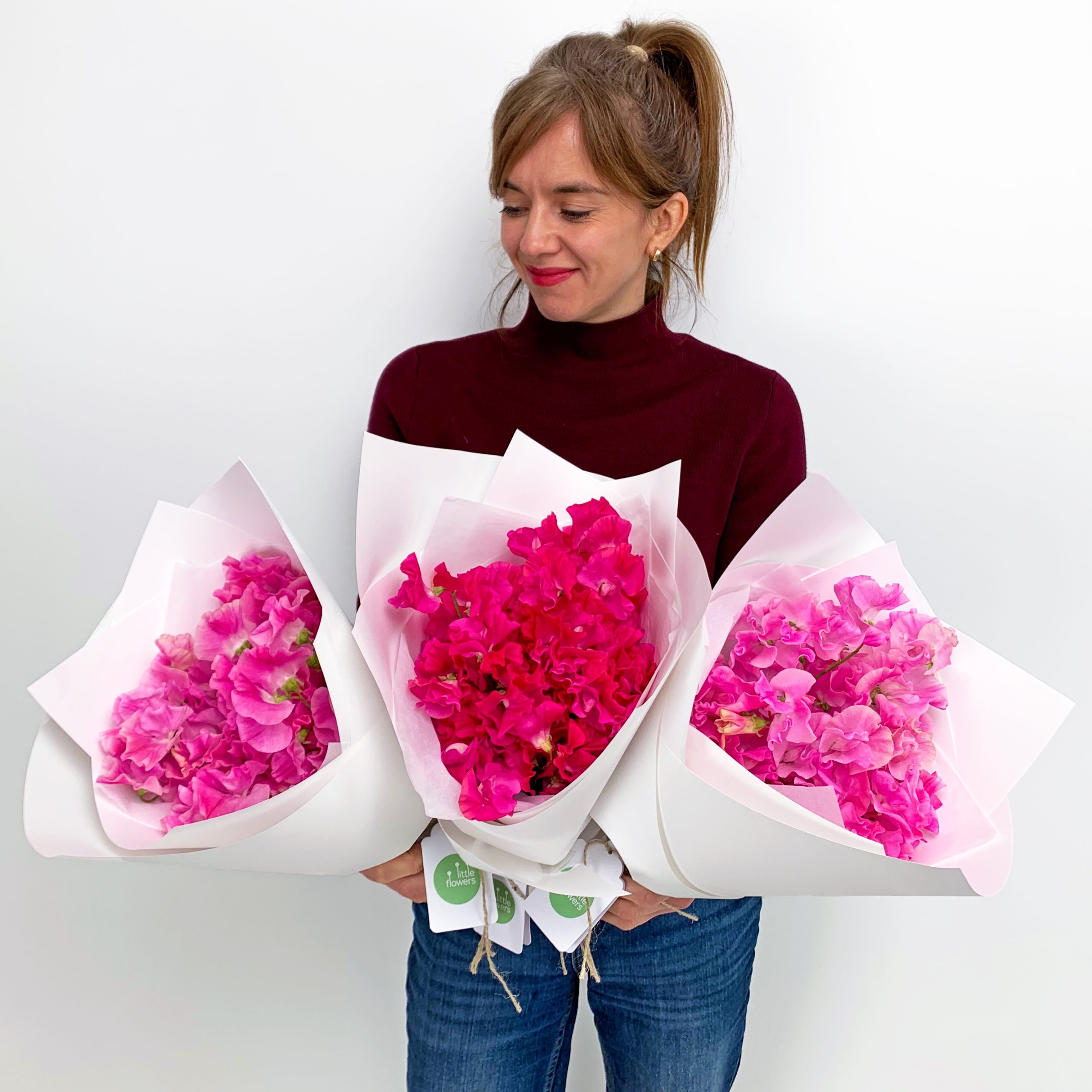 Three bunches of pink and red sweet peas in white paper wrapping - Sydney flower delivery